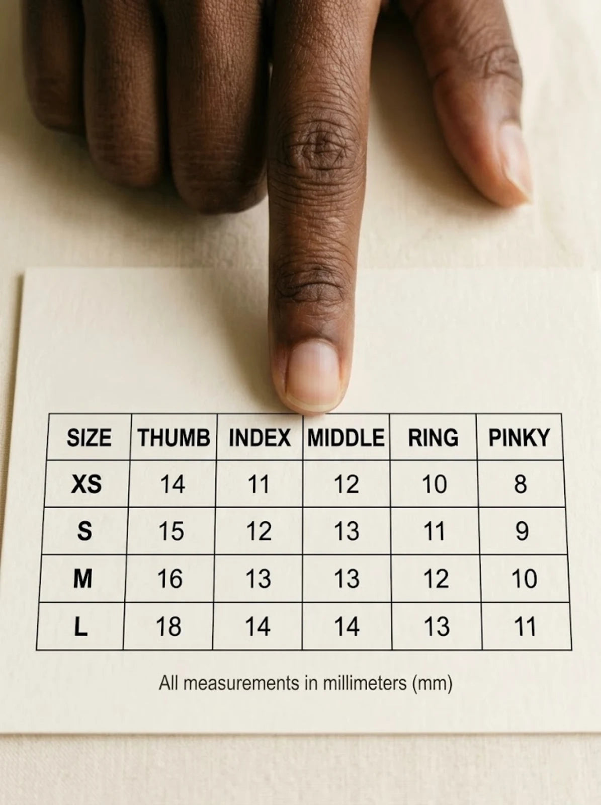 Fingertip pointing at printed size chart with XS S M L columns